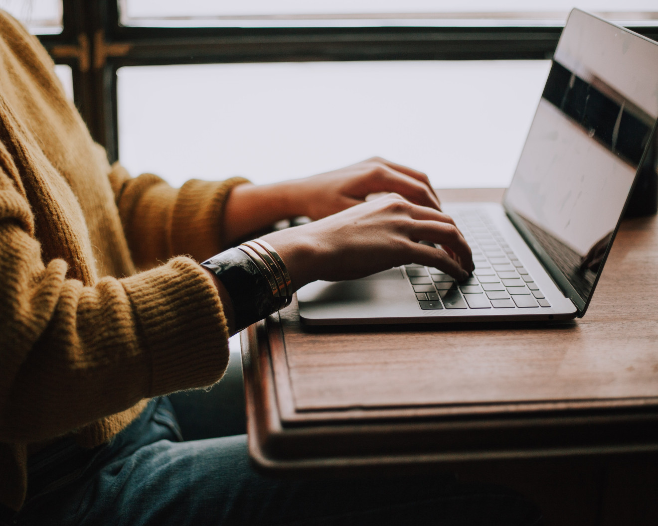 Zwei Hände tippen auf einer Laptop-Tastatur.