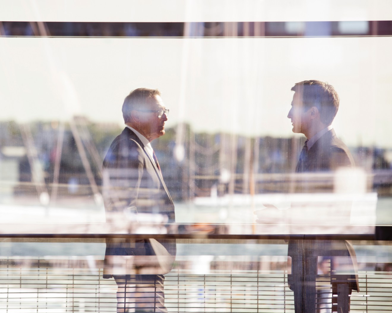 Unternehmensführung. Ein modernes Bürogebäude. Drei Personen unterhalten sich.