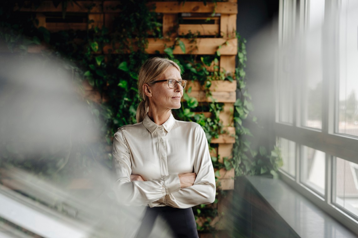Corporate Social Responsibility, eine Frau schaut aus dem Fenster