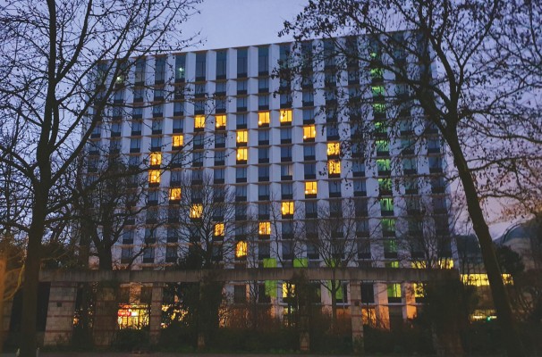 A modern, illuminated building at night.