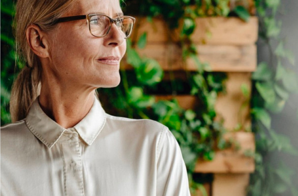 Portrait of an employee in front of a greenery wall.